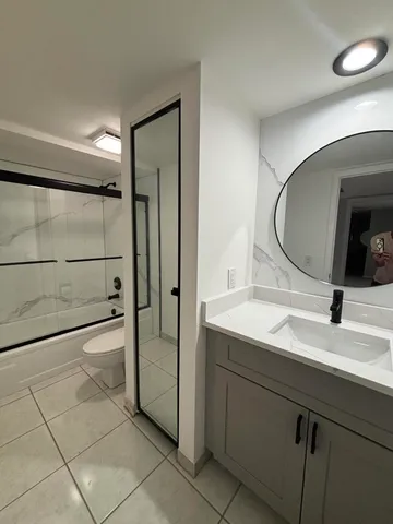 a view of a patio with a table and chairs and a barbeque