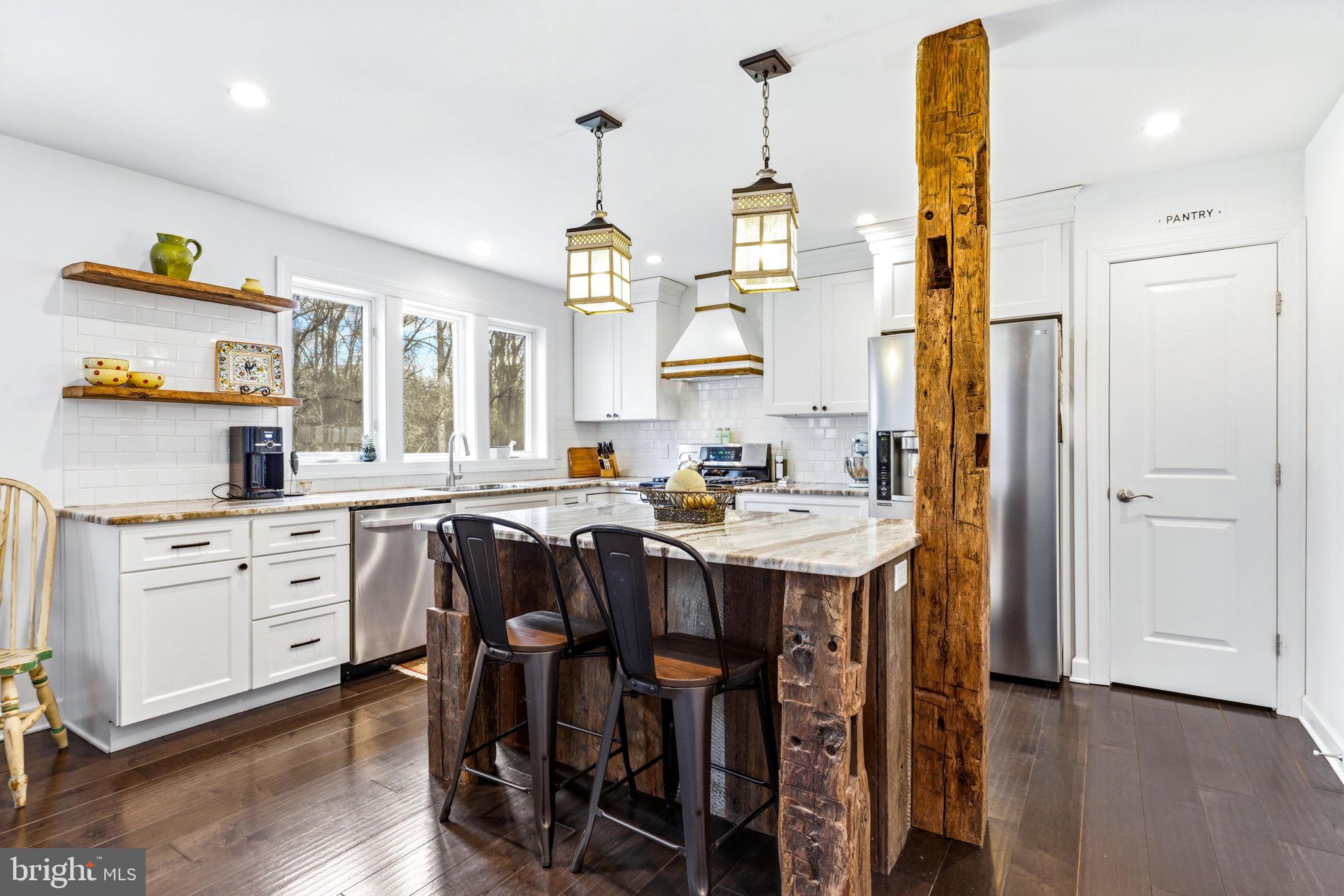 4126 Hedgehill Lane Phoenix, MD 21131 - Photo 6 of 54 a kitchen with stainless steel appliances kitchen island granite countertop a table chairs and a wooden floors