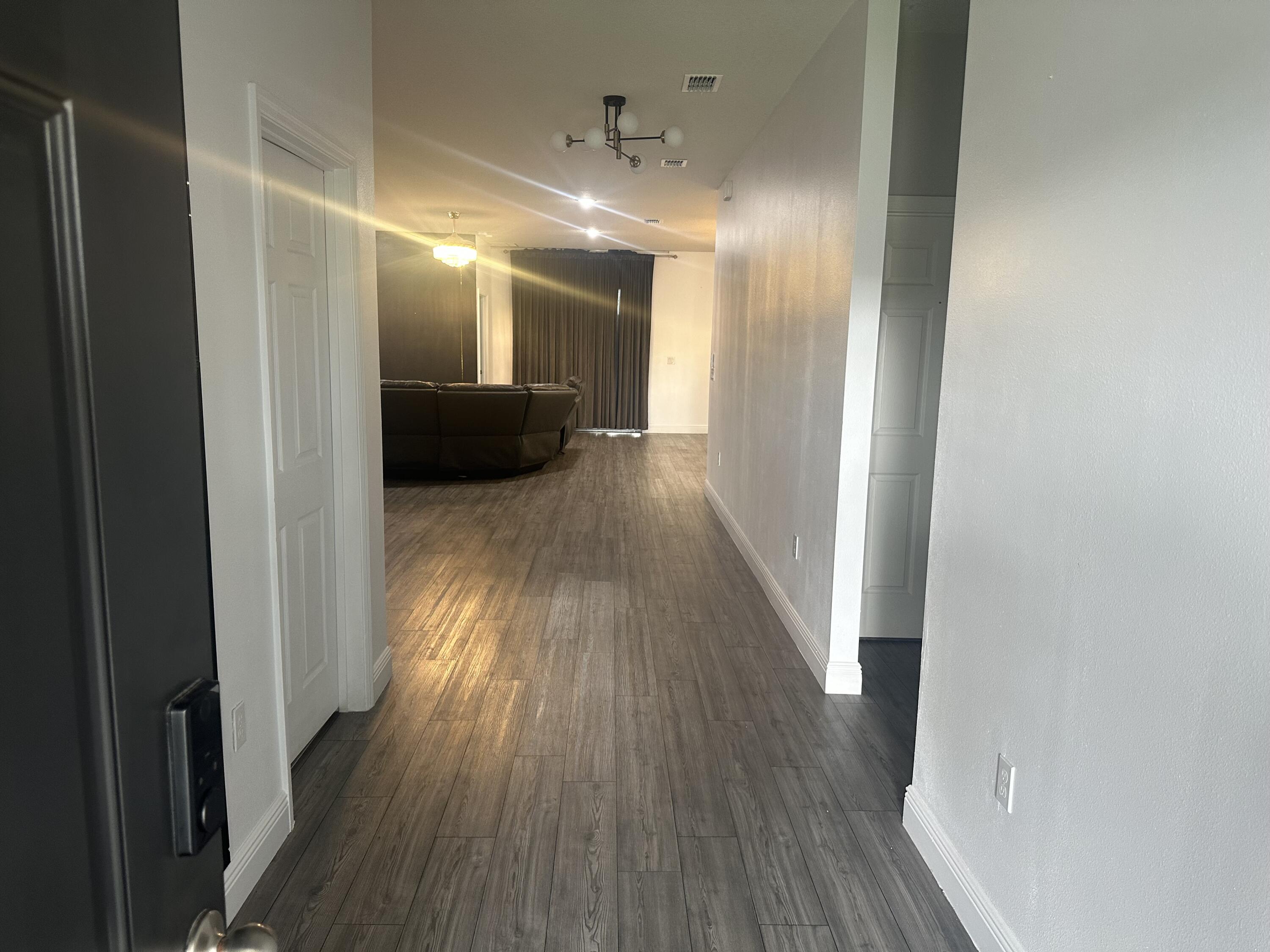 1218 Southwest Parma Avenue Port St. Lucie, FL 34953 - Photo 2 of 11 a view of a hallway with wooden floor