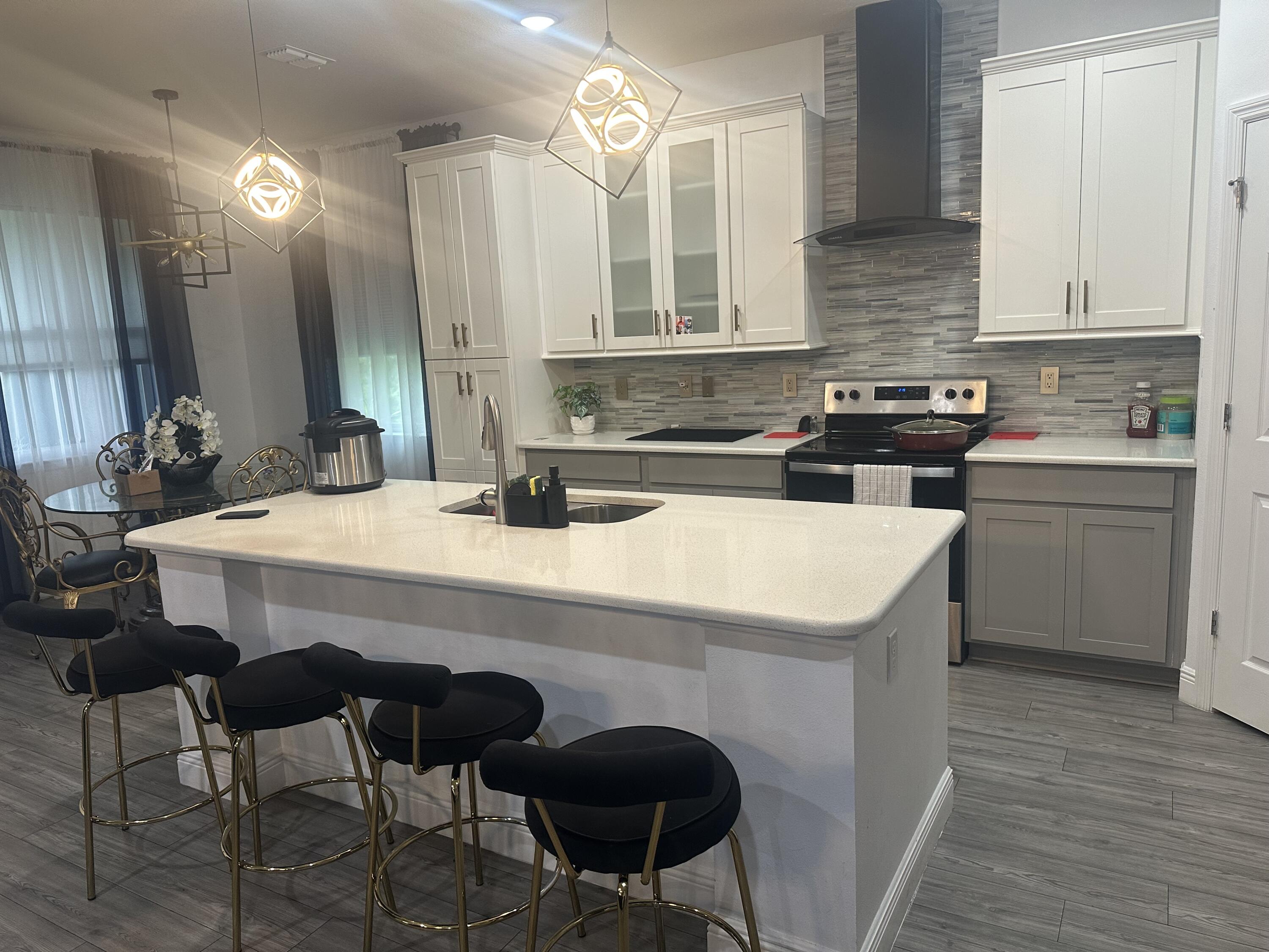 1218 Southwest Parma Avenue Port St. Lucie, FL 34953 - Photo 4 of 11 a kitchen with a table chairs stove and cabinets