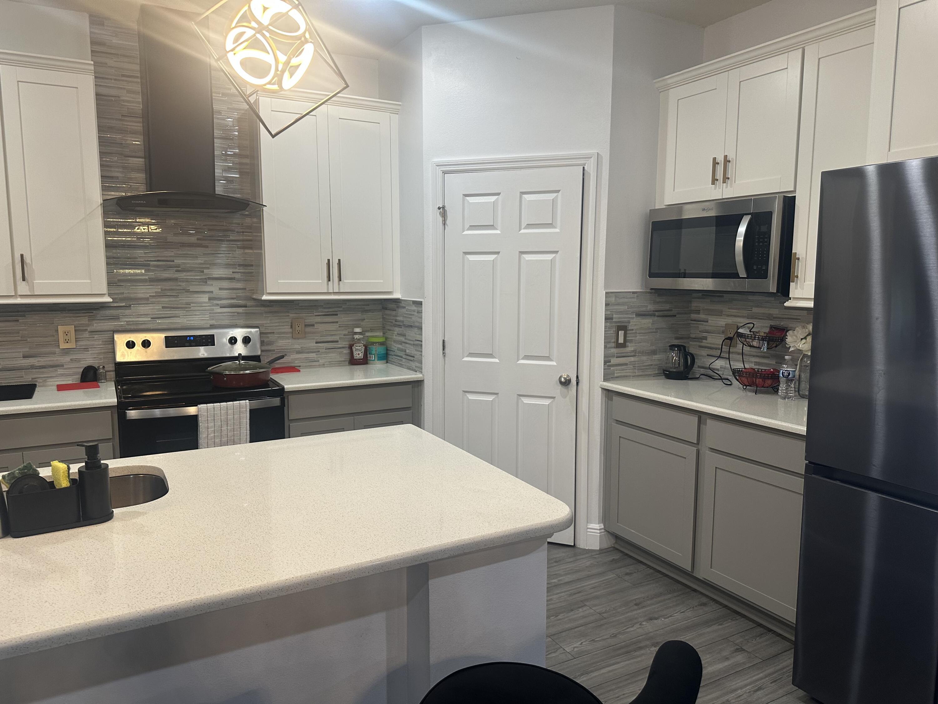 1218 Southwest Parma Avenue Port St. Lucie, FL 34953 - Photo 5 of 11 a kitchen with a sink a stove and refrigerator