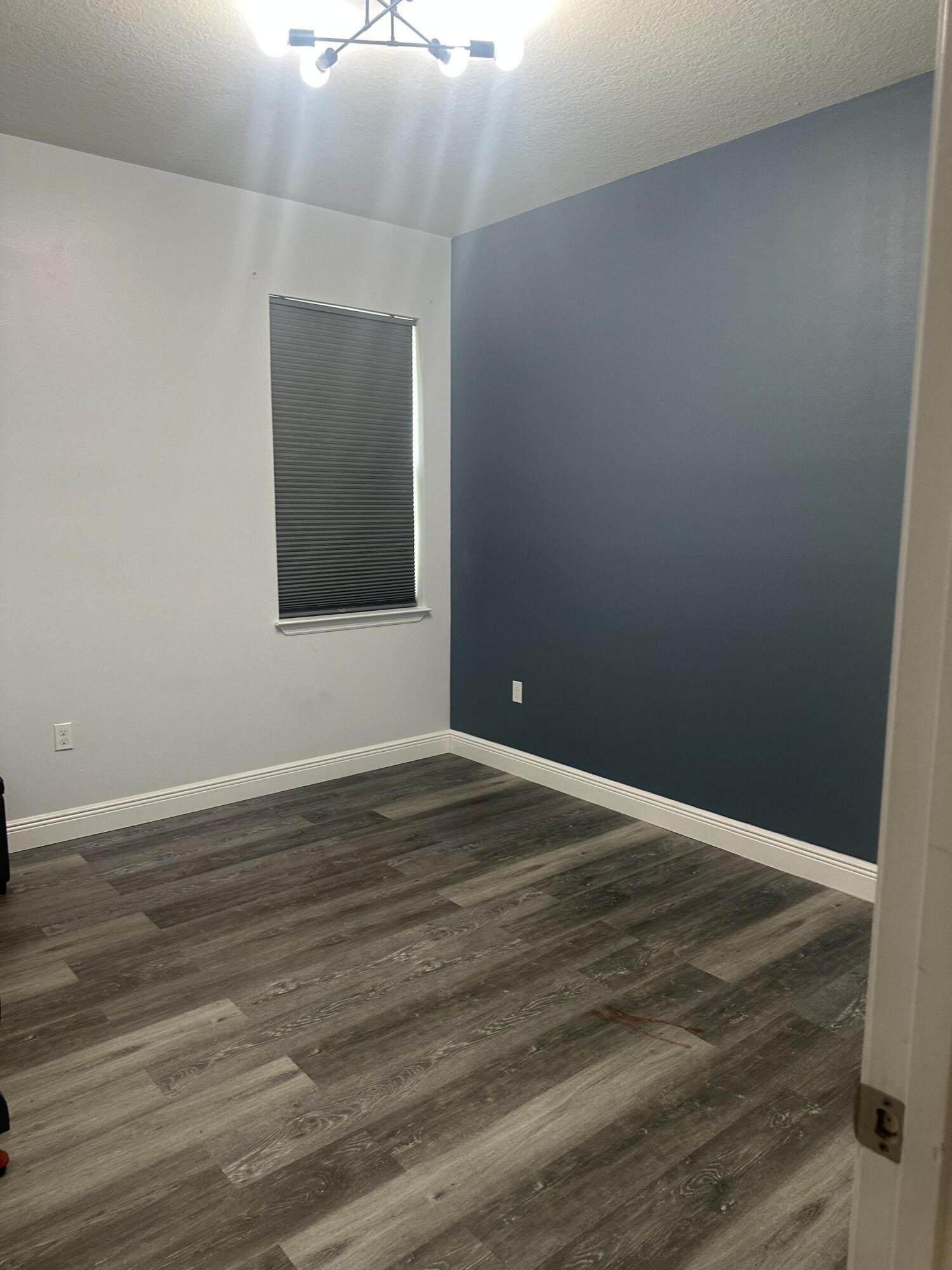 1218 Southwest Parma Avenue Port St. Lucie, FL 34953 - Photo 9 of 11 a view of an empty room with wooden floor and a window