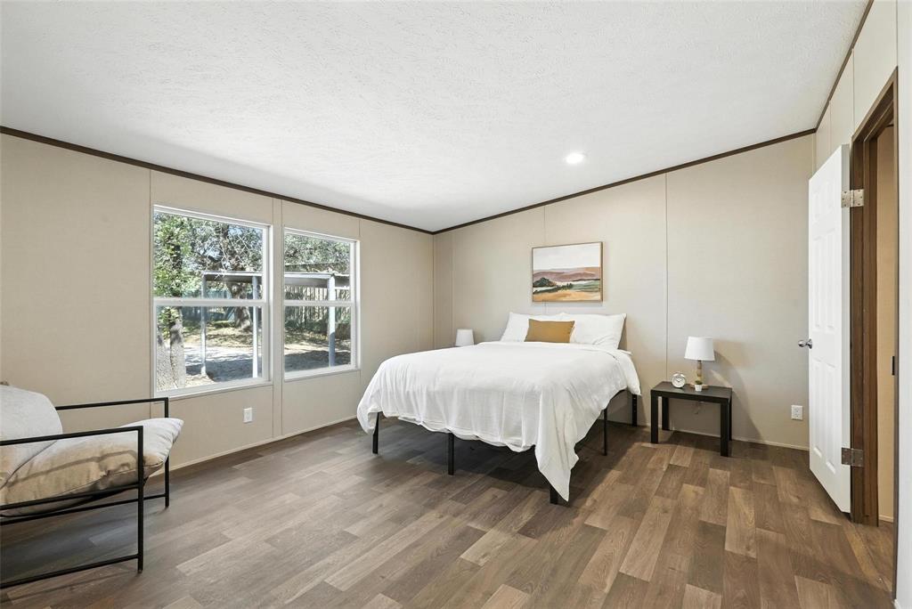 131 Kelly Court Azle, TX 76020 - Photo 13 of 22 a spacious bedroom with a large bed and a large window