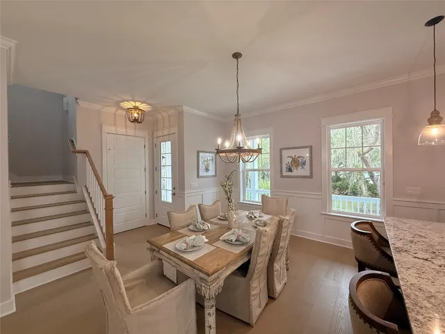 a room with a chandelier and wooden floors