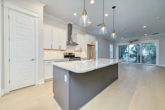 a open kitchen with a granite countertop sink a stove and a wooden floors