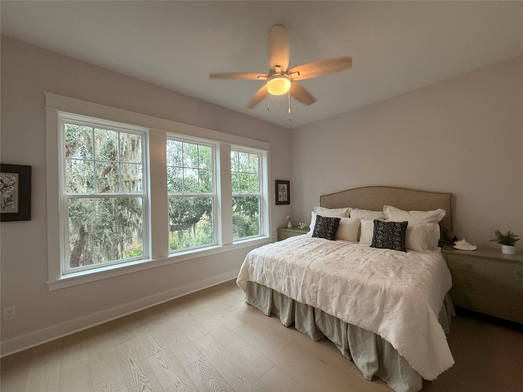 96561 Bay View Drive Fernandina Beach, FL 32034 - Photo 19 of 36 a bedroom with a large bed and a chandelier