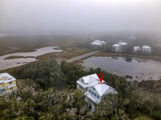 a kitchen with stainless steel appliances granite countertop a refrigerator a stove a sink a dining table and chairs with wooden floor