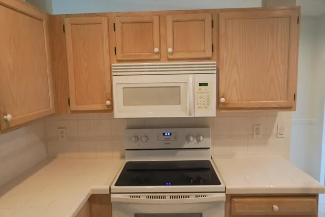 a stove top oven sitting inside of a kitchen