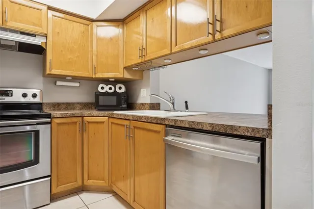 a kitchen with granite countertop cabinets stainless steel appliances and a sink