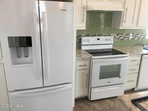 a kitchen with white cabinets and white appliances