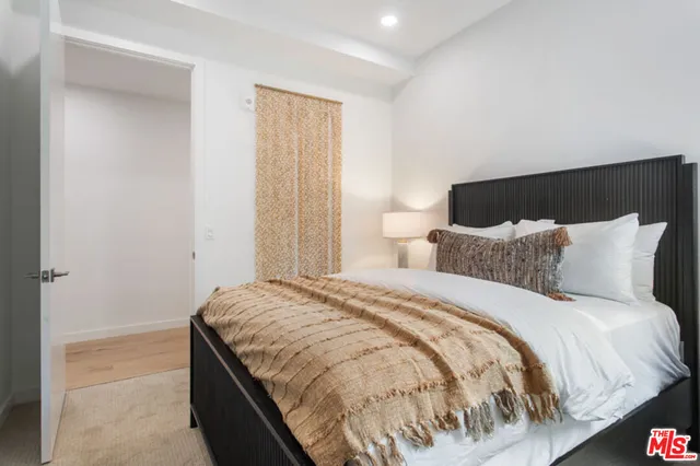 a bed sitting in a bedroom next to a bathroom