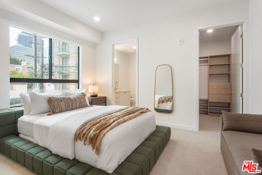 10310 Santa Monica Boulevard, Unit 612 Los Angeles, CA 90025 - Photo 15 of 37 a bedroom with a bed couch and large window