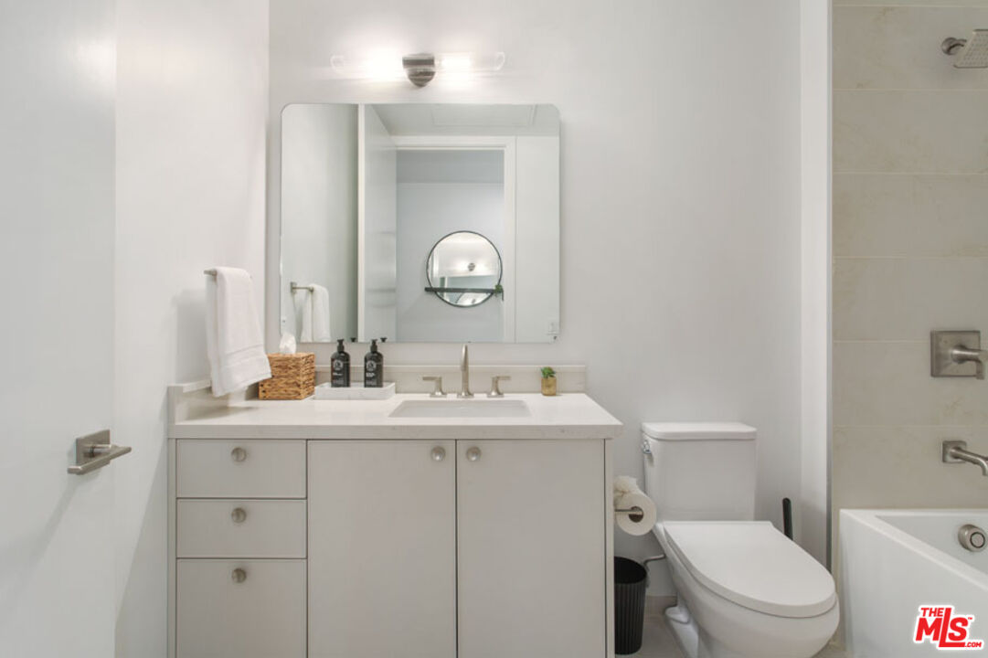 10310 Santa Monica Boulevard, Unit 612 Los Angeles, CA 90025 - Photo 17 of 37 a bathroom with a toilet a sink and mirror