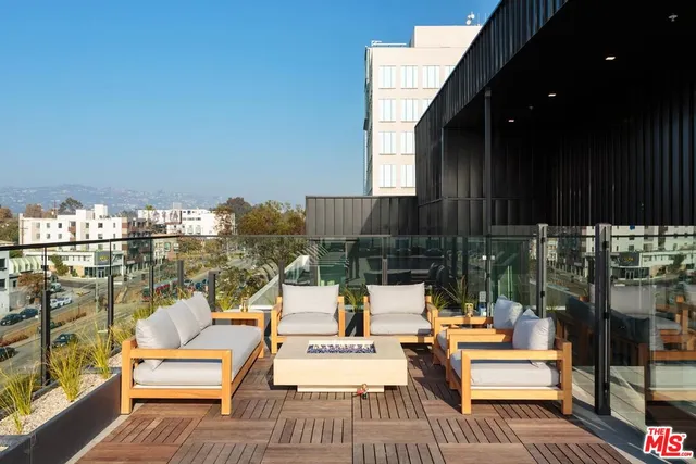 a view of a balcony with chairs and wooden floor