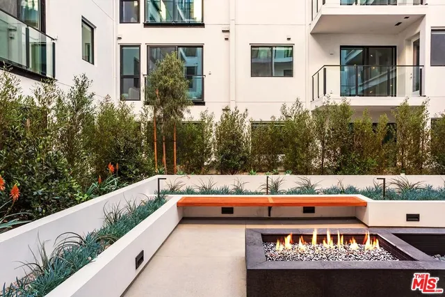 a view of a back yard of the house with a bench