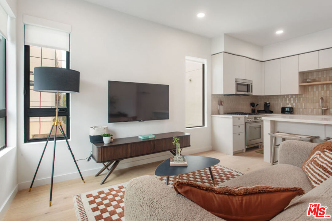 10310 Santa Monica Boulevard, Unit 612 Los Angeles, CA 90025 - Photo 7 of 37 a living room with furniture and a flat screen tv