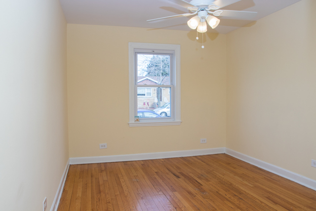 3943 West 83rd Street Chicago, IL 60652 - Photo 4 of 16 wooden floor in an empty room with a window