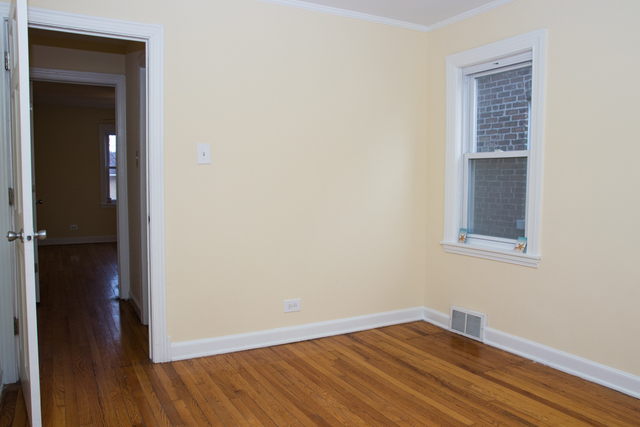 3943 West 83rd Street Chicago, IL 60652 - Photo 6 of 16 a view of an empty room with wooden floor and a window
