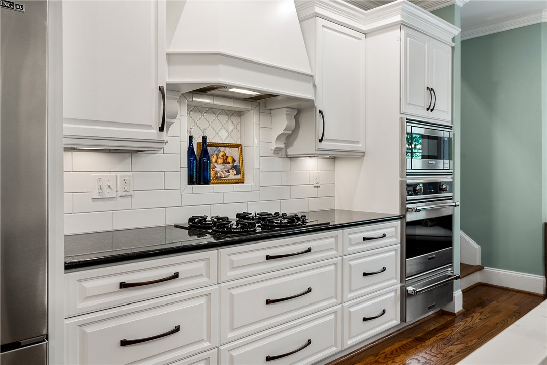 200 Graylyn Drive Anderson, SC 29621 - Photo 12 of 48 Gleaming wood floors complement the pristine white cabinetry and dark countertops in this well-appointed culinary space.