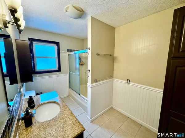 a bathroom with a granite countertop sink and a mirror