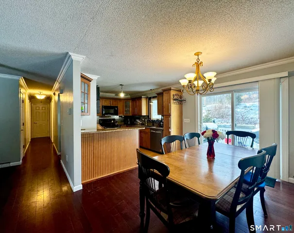 a view of a dining room with furniture a chandelier and wooden floor