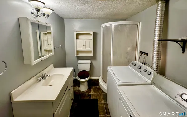 a bathroom with a sink a toilet and mirror
