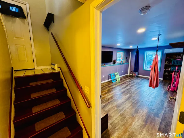 a view of a hall with wooden floor and stairs