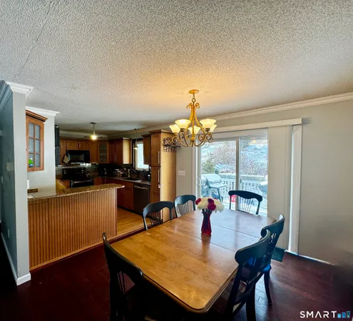 a kitchen with a dining table chairs and refrigerator