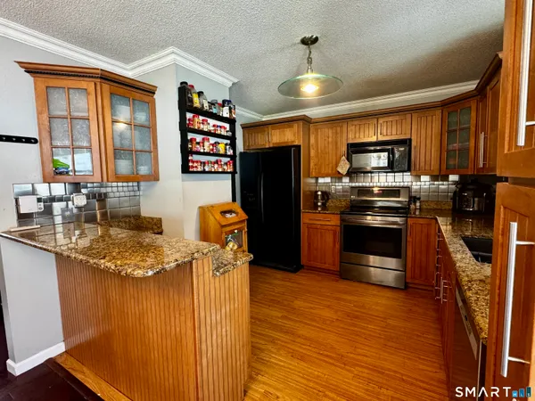 a kitchen with stainless steel appliances granite countertop a refrigerator stove and sink