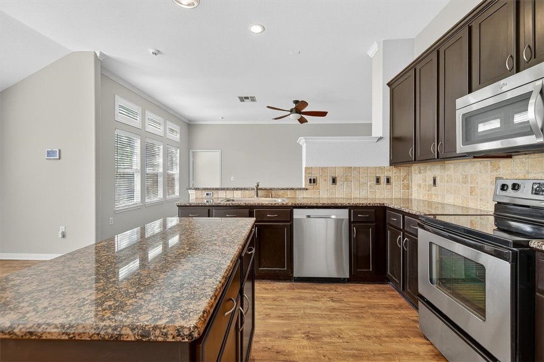 7506 Exeter Corpus Christi, TX 78414 - Photo 12 of 40 a kitchen with stainless steel appliances granite countertop a stove top oven a sink and dishwasher