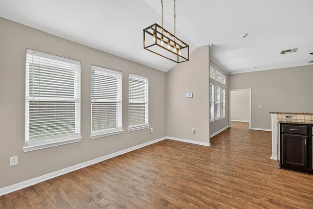 a view of empty room with wooden floor and fireplace