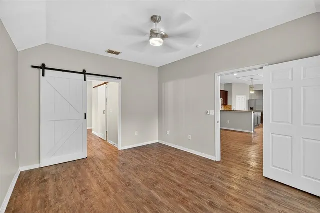a view of a livingroom with wooden floor and a ceiling fan