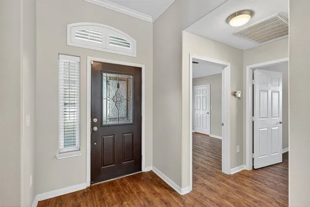 a view of a hallway with wooden floor and closet