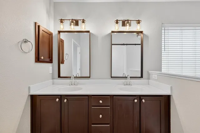 a bathroom with double vanity sinks and a mirror