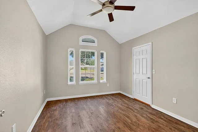 an empty room with a window and a ceiling fan