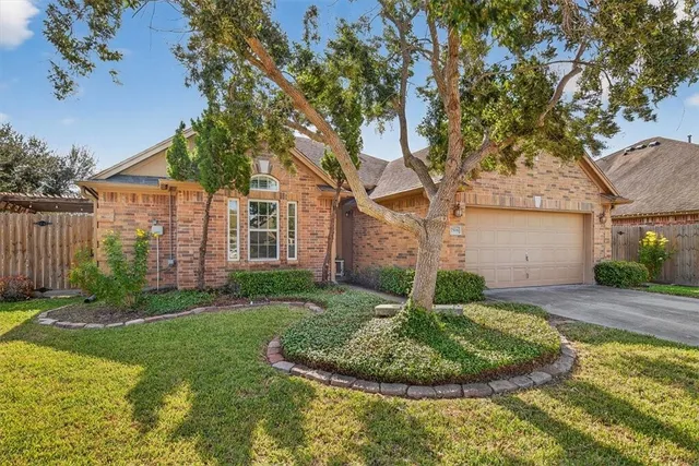 a view of a house with backyard and trees
