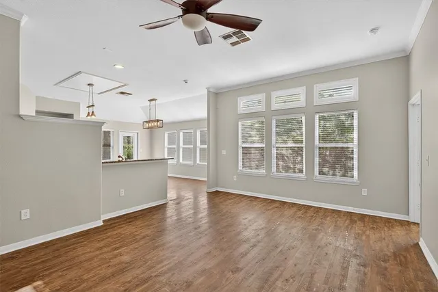 a view of an empty room with a window and wooden floor