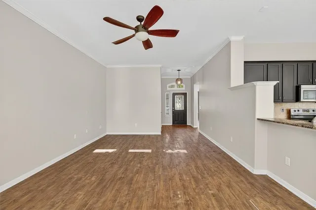a view of a kitchen with a wooden floor and a ceiling fan