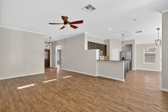 a view of a kitchen with a sink and dishwasher a refrigerator with wooden floor