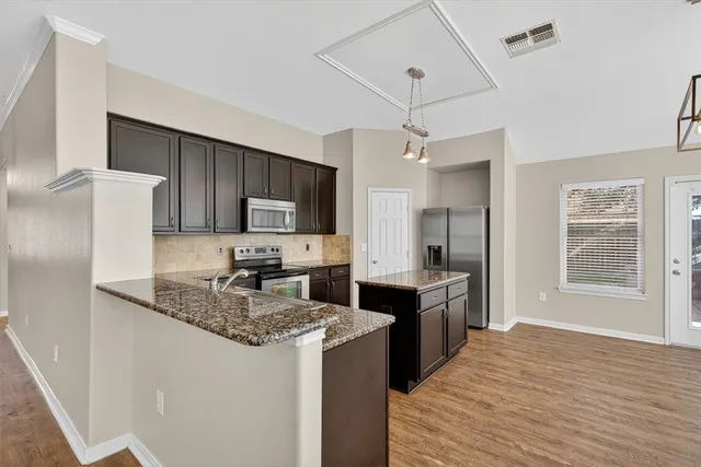 a kitchen with stainless steel appliances granite countertop a sink stove and refrigerator