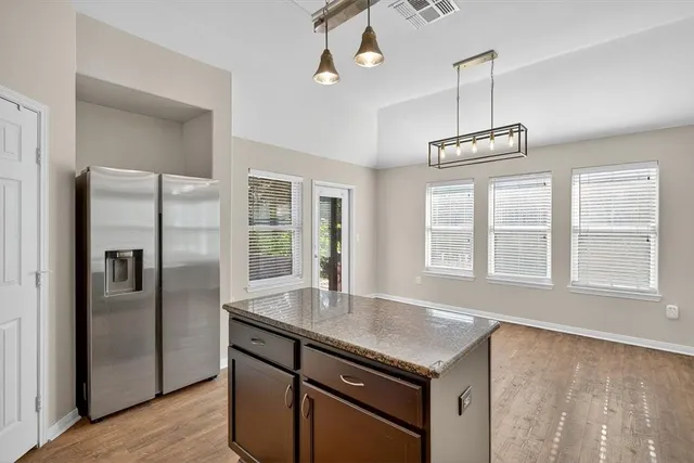 a kitchen with stainless steel appliances granite countertop a sink a refrigerator and a window