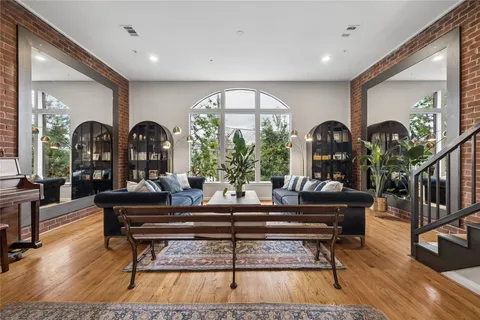 a living room with furniture a lamp and wooden floor