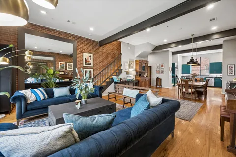 a living room with furniture kitchen view and a large window
