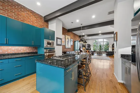 a kitchen with stainless steel appliances granite countertop a stove and a wooden floors