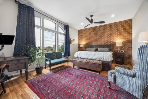 a bedroom with a bed a couch and a large window