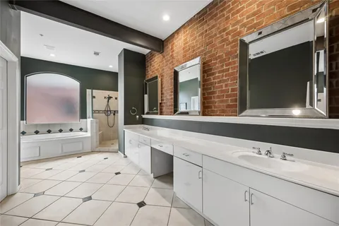 a bathroom with a double vanity sink mirror and bathtub