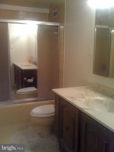 5225 Pooks Hill Road, Unit 406N Bethesda, MD 20814 - Photo 4 of 18 a bathroom with a granite countertop sink toilet and shower