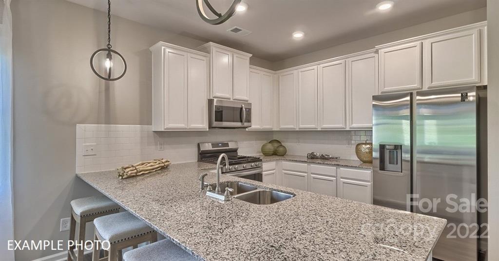 7200 Indigo Way Denver, NC 28037 - Photo 3 of 11 a kitchen with stainless steel appliances granite countertop a sink refrigerator and cabinets