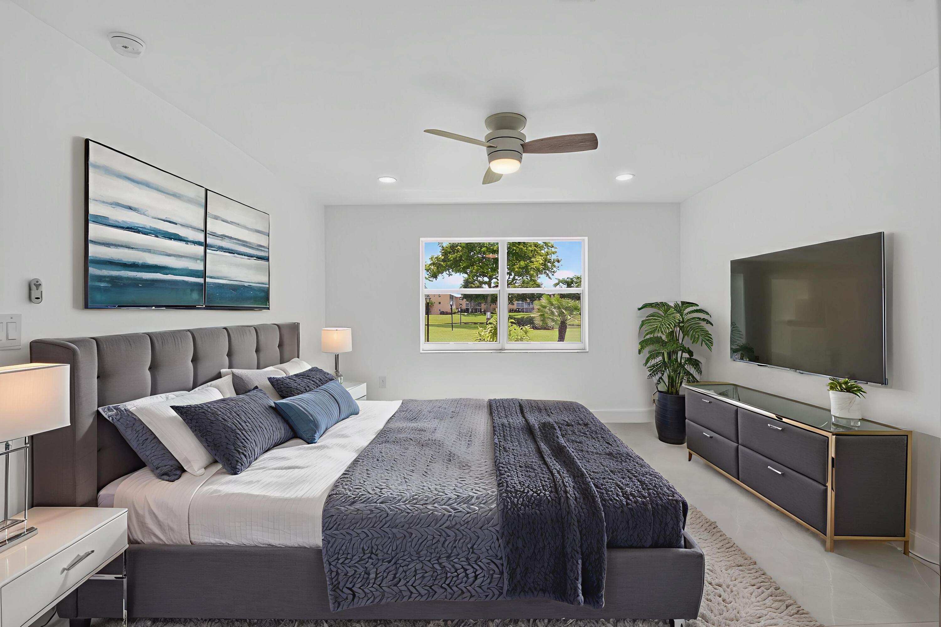 9880 Marina Boulevard, Unit 1509 Boca Raton, FL 33428 - Photo 15 of 43 a bedroom with a bed and a flat screen tv