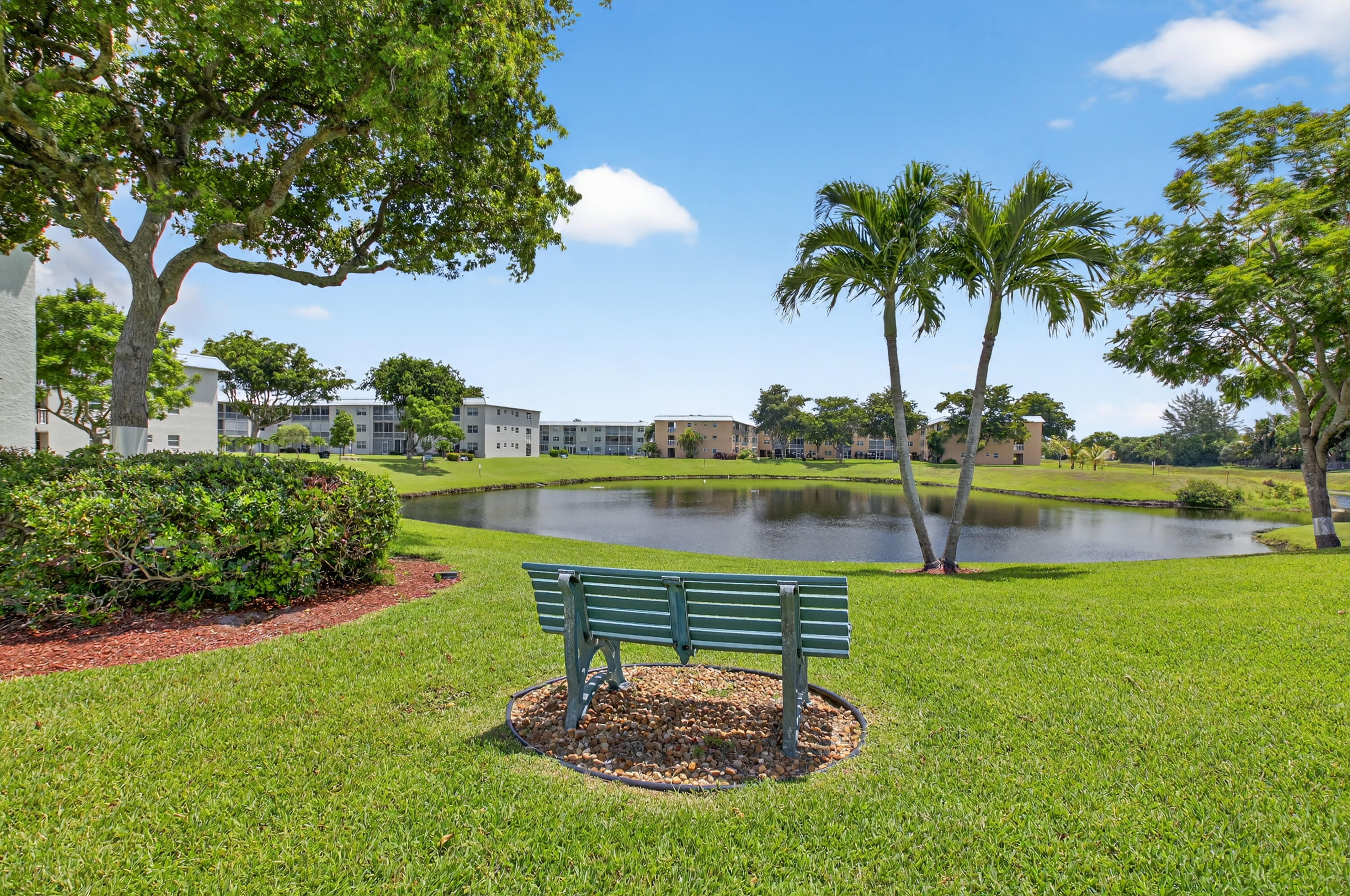 9880 Marina Boulevard, Unit 1509 Boca Raton, FL 33428 - Photo 3 of 43 a lake with a big yard and palm trees